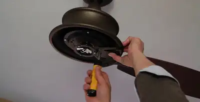 Electrician installing ceiling fan mounting bracket and fixture in Scottsdale, AZ