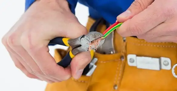 licensed electrician securing electrical wiring with professional tools during service work in Scottsdale, AZ