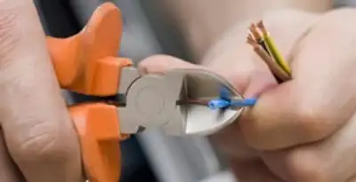 licensed electrician performing precise wire cutting and preparation during electrical service in Scottsdale, AZ