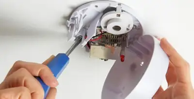 Certified technician wiring smoke detector during installation in Scottsdale, AZ